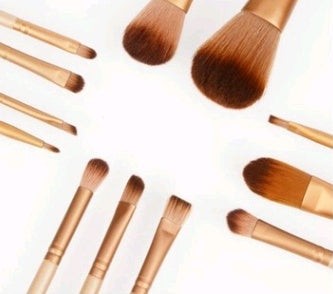 12-piece makeup brush set with wooden handles stored in an iron box