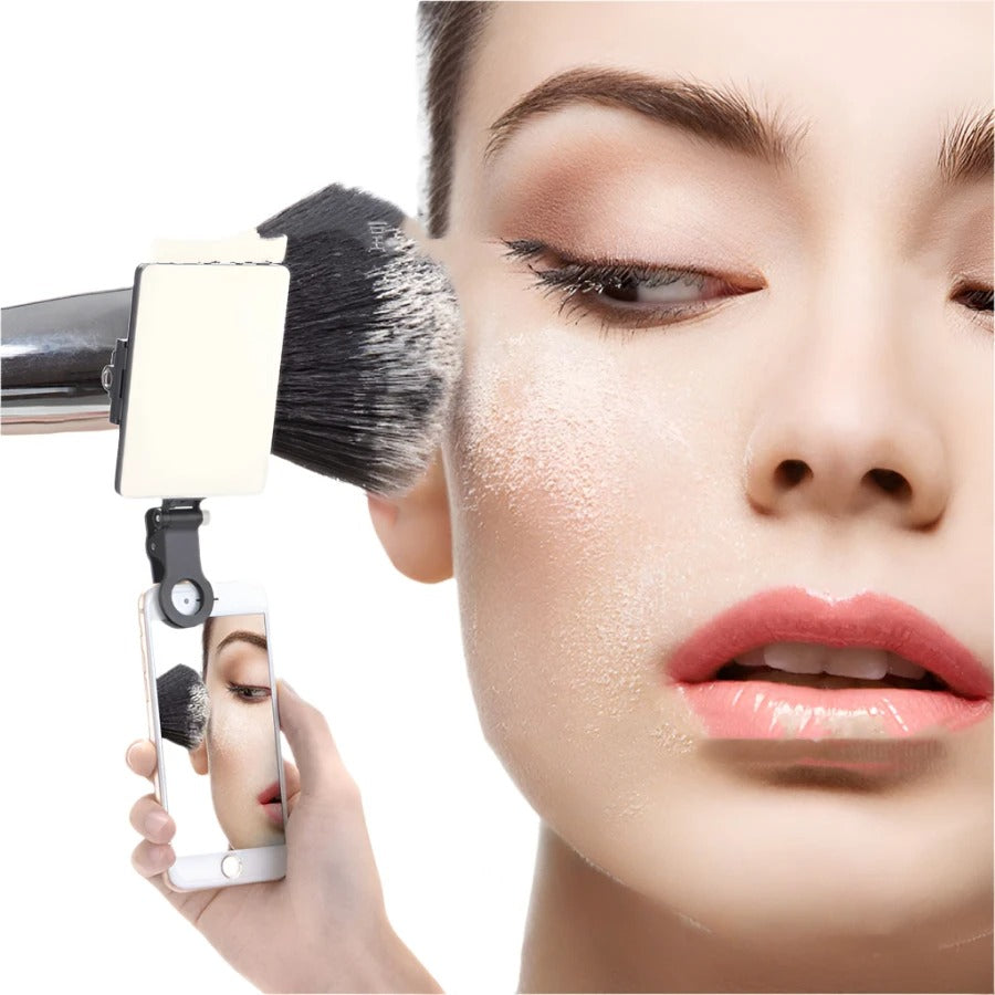 Close-up of a person using a makeup brush with a mirror attachment on a white background